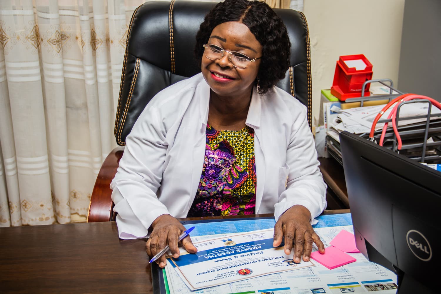 Dr. Wiafe-Addai at her office desk in her doctor’s coat