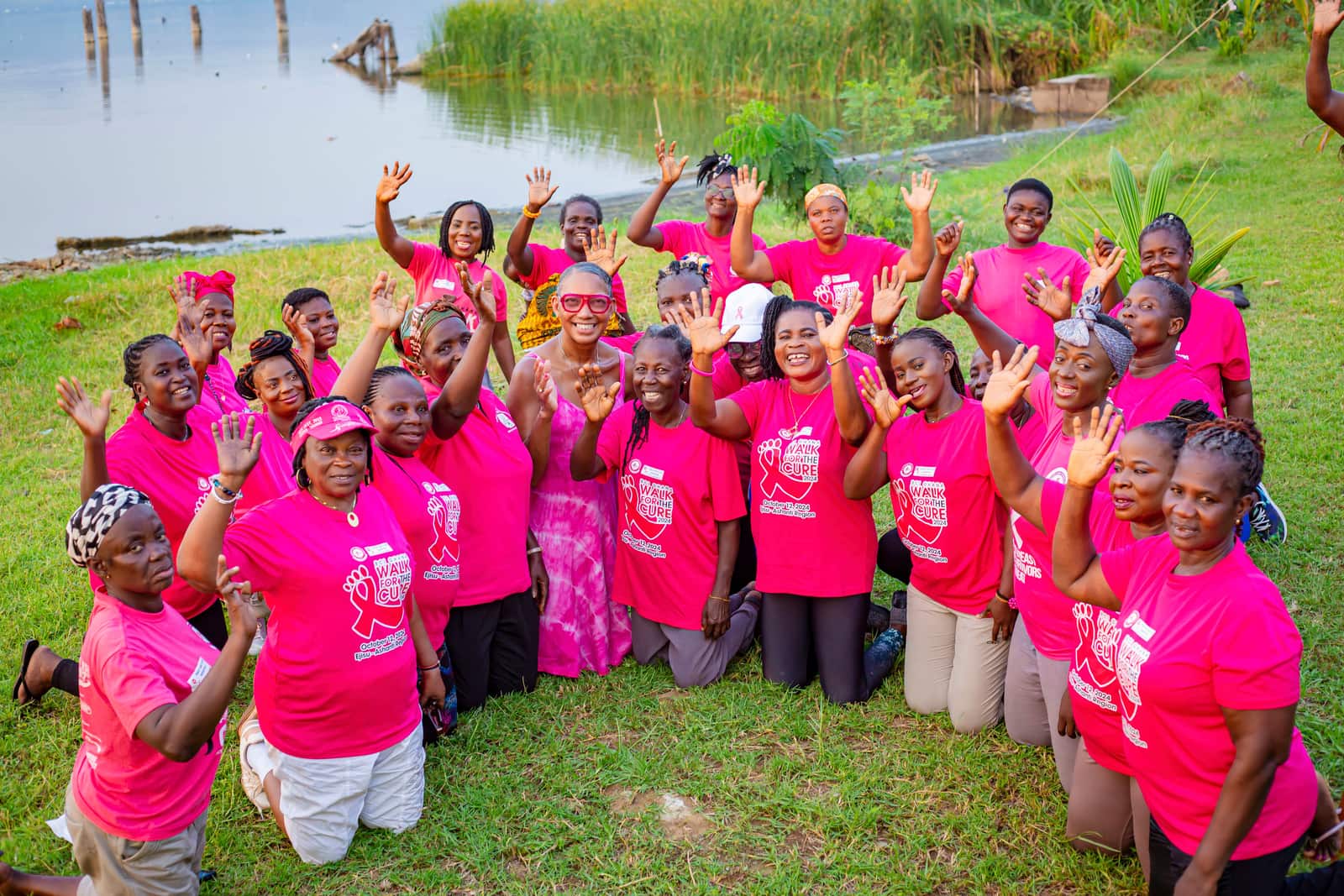 PALSA survivors in Walk for the Cure 2024 shirts waving at a lakeside gathering